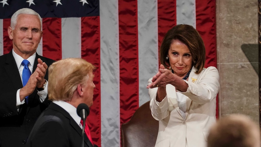 Man turning back to look at a woman wearing a white suit.