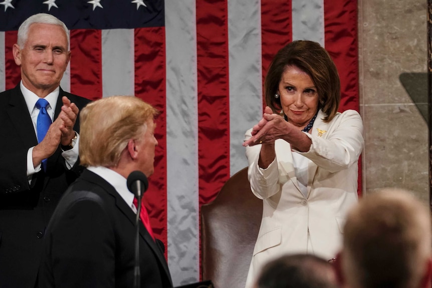 Man turning back to look at a woman wearing a white suit.