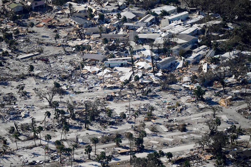 Some houses stand among the debris of houses completely destroyed.