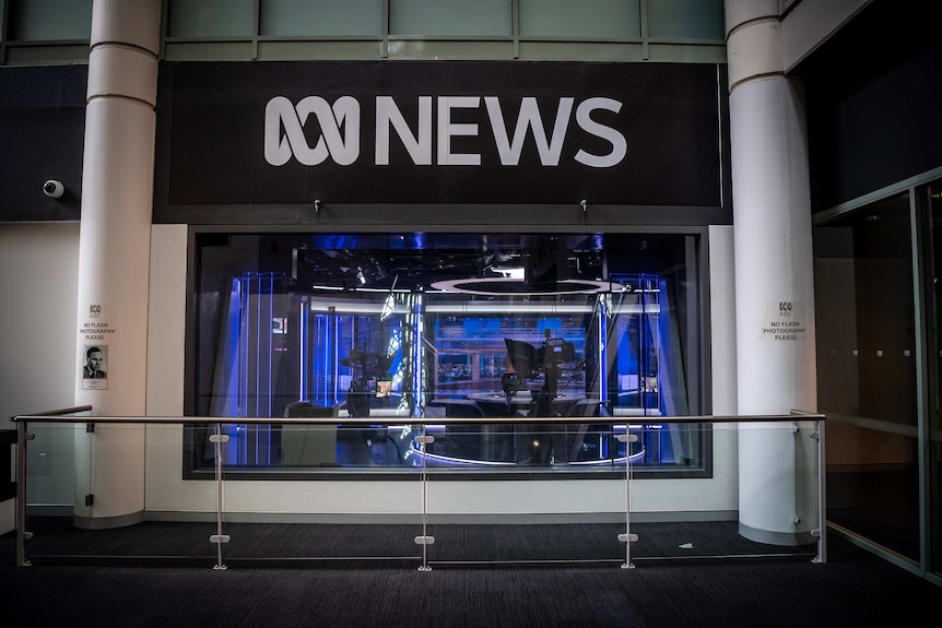 A television studio is seen through glass windows underneath an ABC News logo.