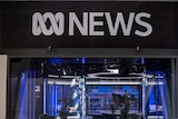 A television studio is seen through glass windows underneath an ABC News logo.