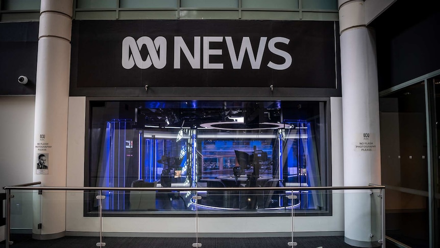 A television studio is seen through glass windows underneath an ABC News logo.