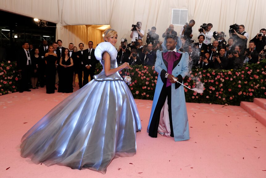 Zendaya wearing a blue, illuminated dress that looks like Disney's Cinderella and Law Roach in a pale blue coat with a wand