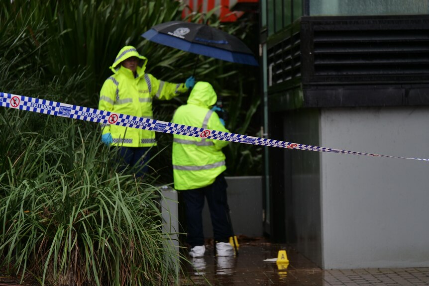 police officers inwith white booties on behind police tape