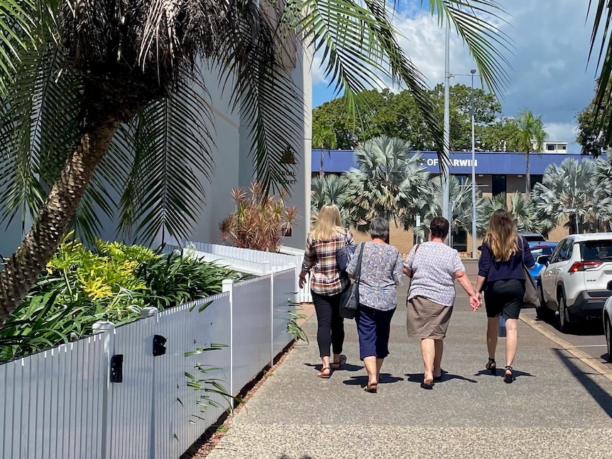 Four women walking along a sidewalk in Darwin. 