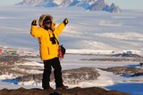 Antarctic expeditioner gesturing outside.