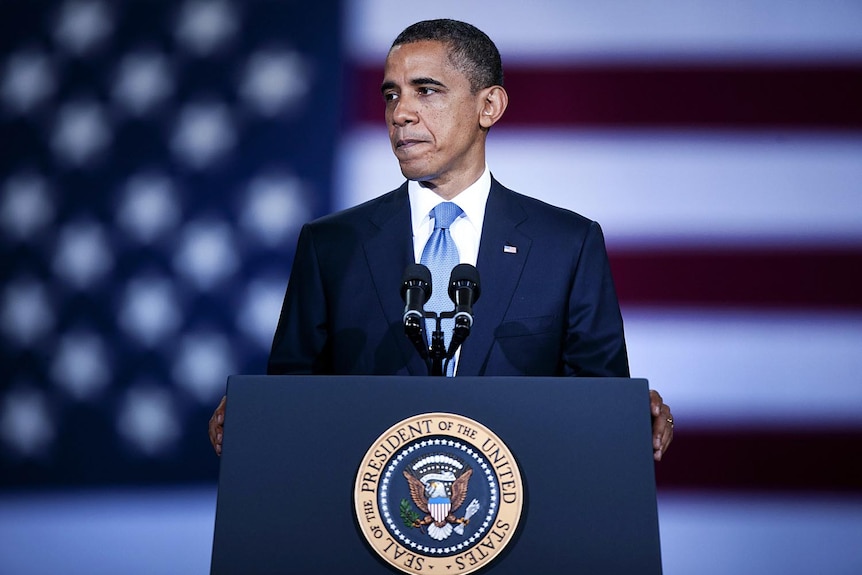 US president Barack Obama pauses while speaking in front of the US flag at the Washington Convention Centre on July 29, 2011.