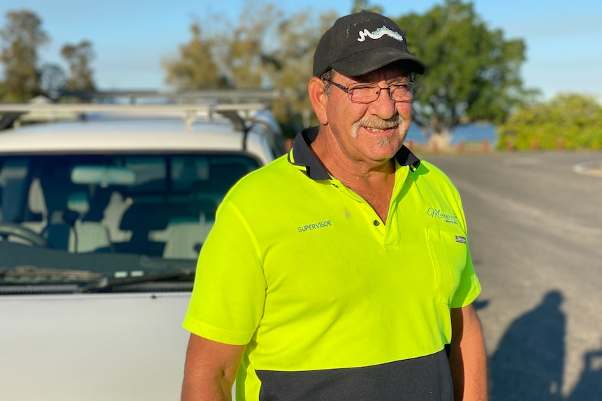 Middle aged man standing in front of ute