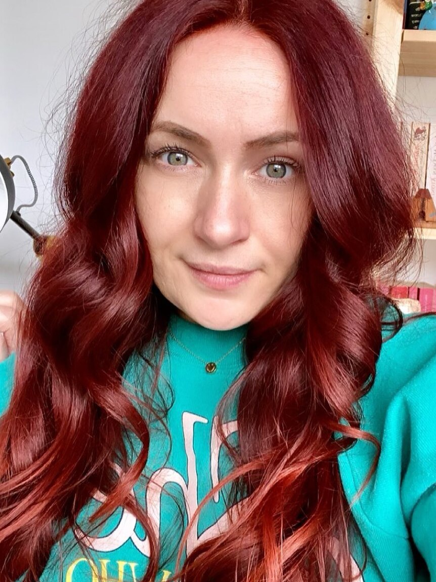 A close up image of a woman with long red hair. 