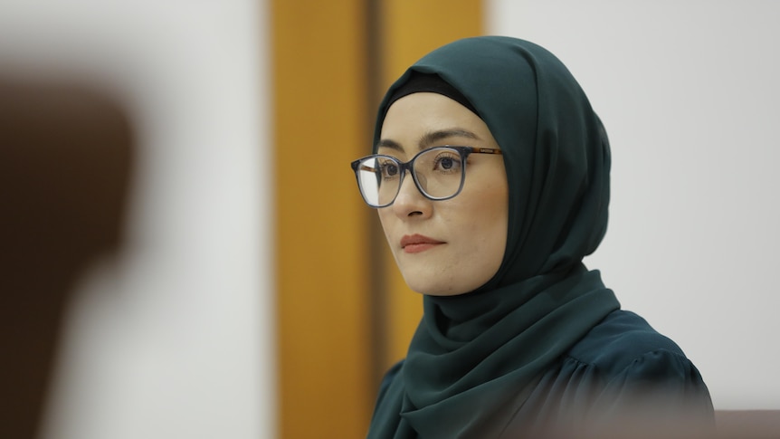 A woman wearing a hijab head scarf and glasses