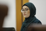 A woman wearing a hijab head scarf and glasses