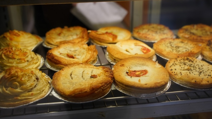 Selection of freshly baked meat pies in bakery.