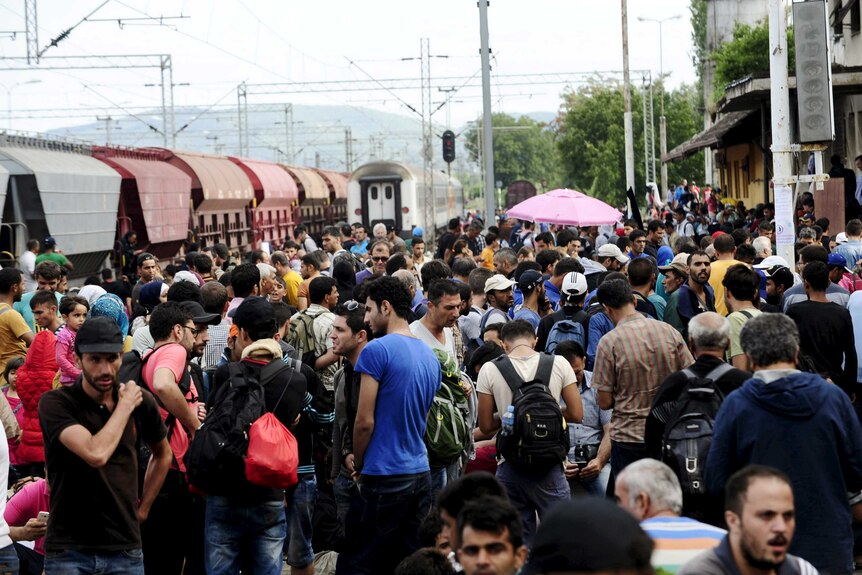 Migrants gather at Gevgelija train station in Macedonia after crossing Greece's border into Macedonia