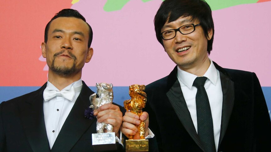 Actor Liao Fan and director Diao Yinan pose with their Berlinale prizes, February 2014