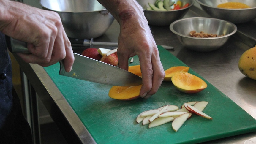 Dwayne Masters cuts up mangoes