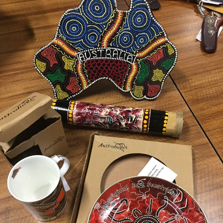 Fake Aboriginal-style souvenirs in a shop, including a plate in the shape of Australia