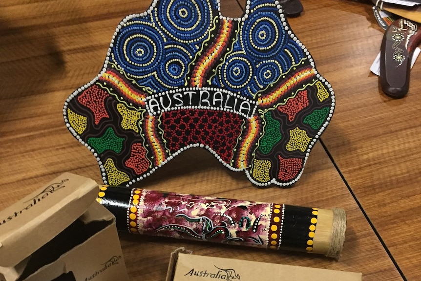 Fake Aboriginal-style souvenirs in a shop, including a plate in the shape of Australia