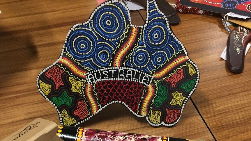 Fake Aboriginal-style souvenirs in a shop, including a plate in the shape of Australia