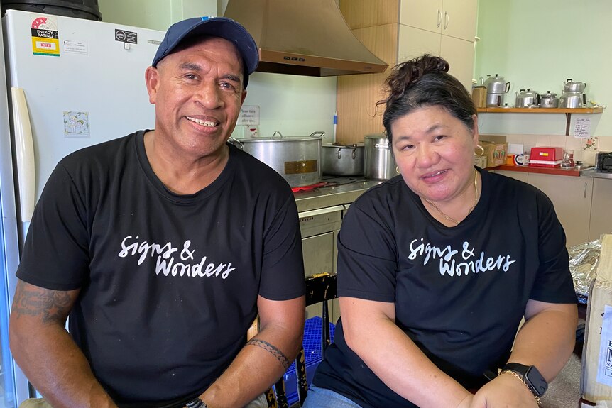 A man and a woman in black t-shirts saying "Signs and wonders".