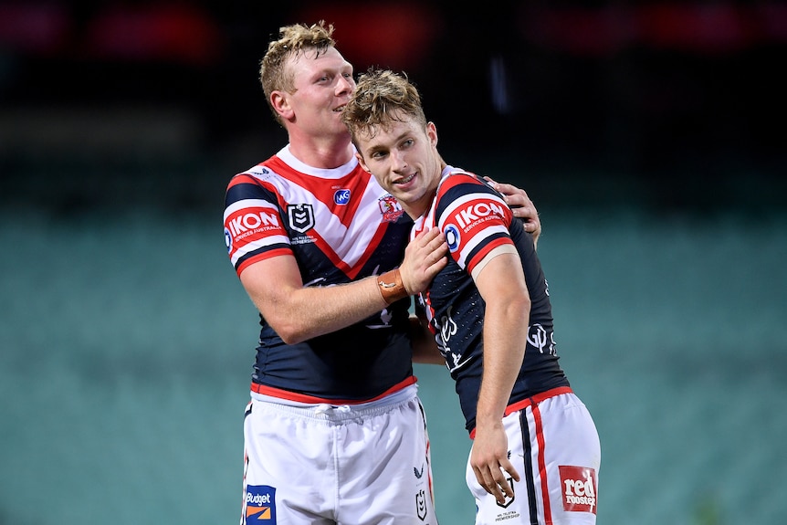 Two Sydney Roosters NRL players embrace as they celebrate beating Cronulla.