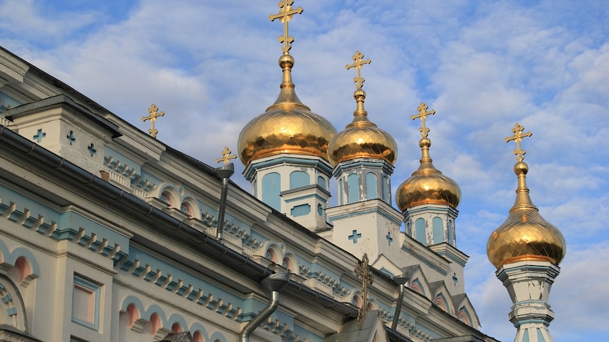 Golden domes above a church in Latvia.