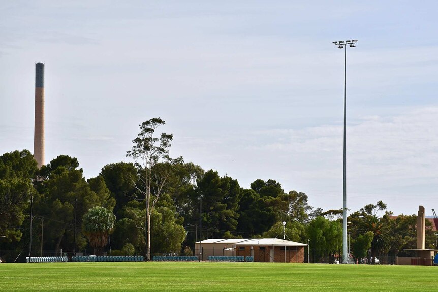 A sporting field at Port Pirie, with the lead smelter stack in the background.