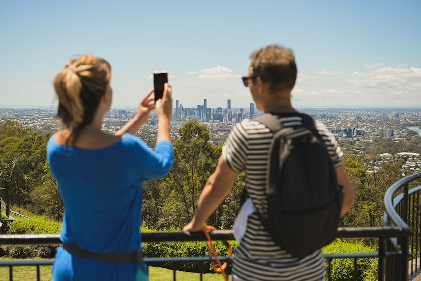 Tourists take photos of Brisbane's skyline view from Mount Coot-tha.