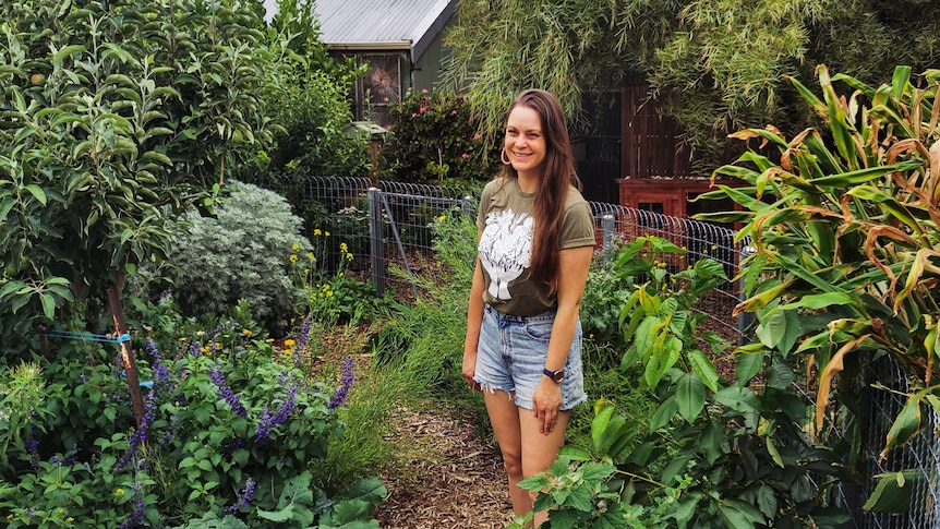 Koren stands amid her urban food forest in her small Adelaide backyard