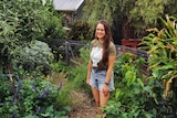 Koren stands amid her urban food forest in her small Adelaide backyard