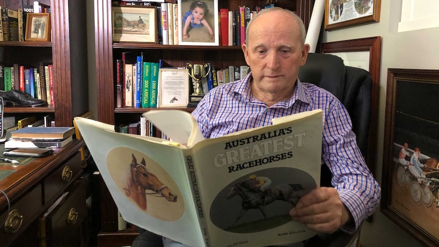 Race calling legend John Tapp reads a book in his office.