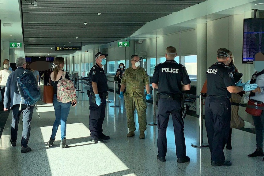 Army and Queensland police officers at a security checkpoint at Brisbane airport on July 31, 2020 screen passenger arrivals.