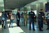 Army and Queensland police officers at a security checkpoint at Brisbane airport on July 31, 2020 screen passenger arrivals.