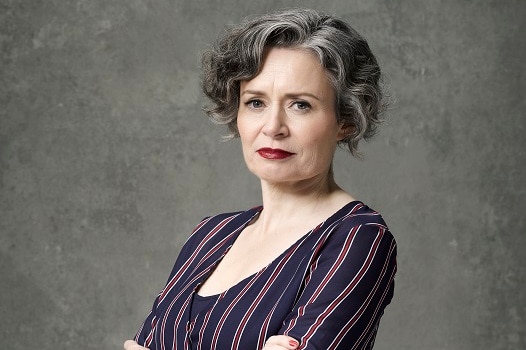 Comedian Judith Lucy poses for a portrait in a studio looking serious, her performances have touched on her single life at 50.