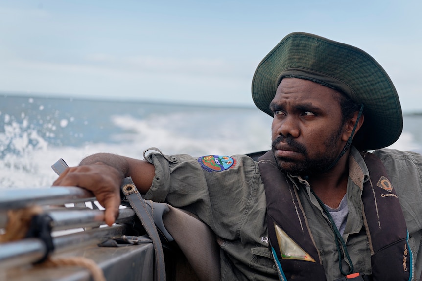 Jonah Ryan stares across the water on a moving motor boat off the coast of Maningrida.