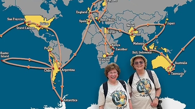 Two elderly ladies stand in front of a world map showing where they have been