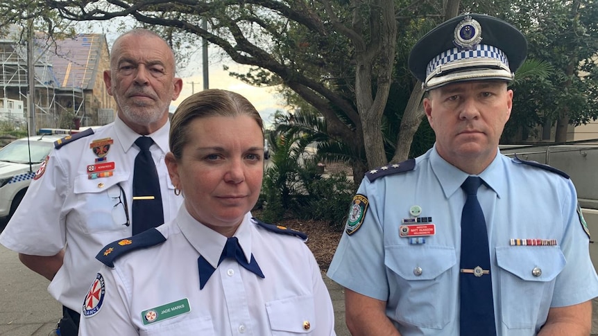 Two Ambulance officers and a Police Officer with concerned looks on their faces