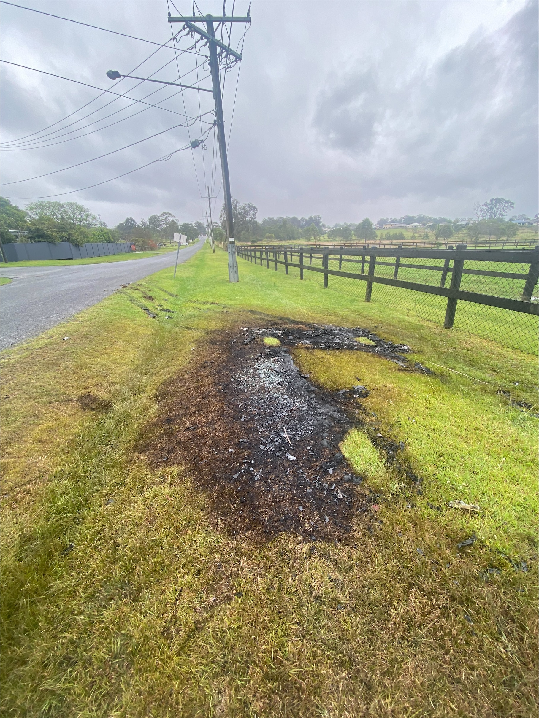A large patch o cgrass burnt next to a road.