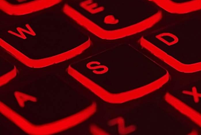A computer keyboard lit up in red.