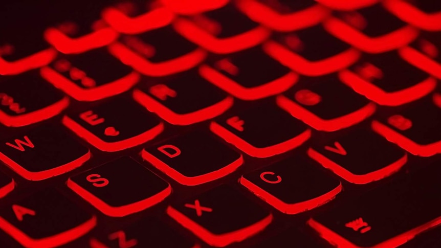 A computer keyboard lit up in red.