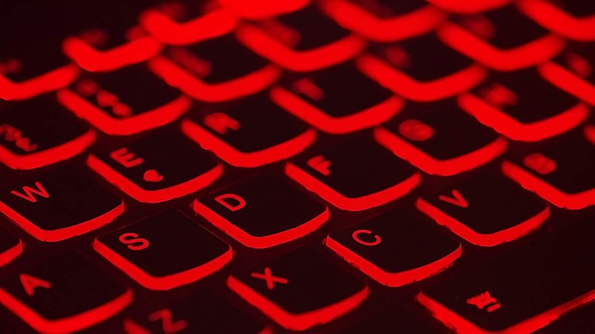 A computer keyboard lit up in red.