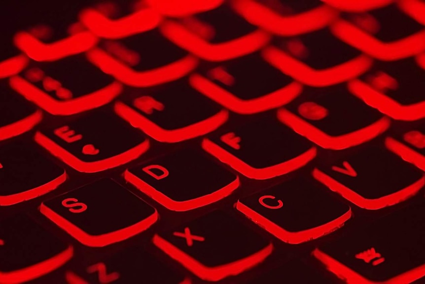 A computer keyboard lit up in red.