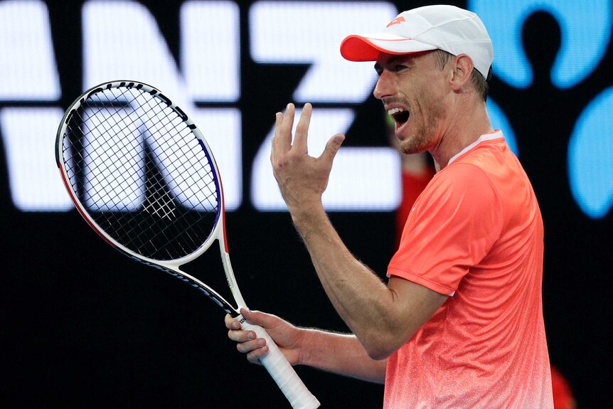 John Millman raises his hand and grimaces in frustration at the Australian Open