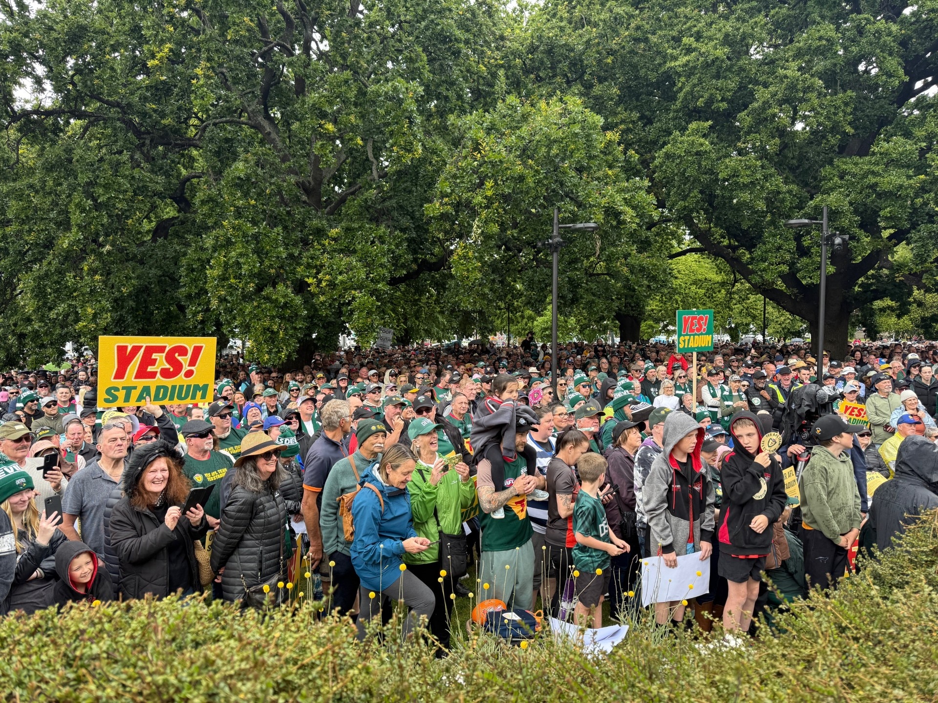 a large crown on a green space, one with a placard reading 'yes stadium'