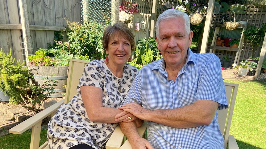 Joan and Michael Kennedy sit in chairs in their back yard.