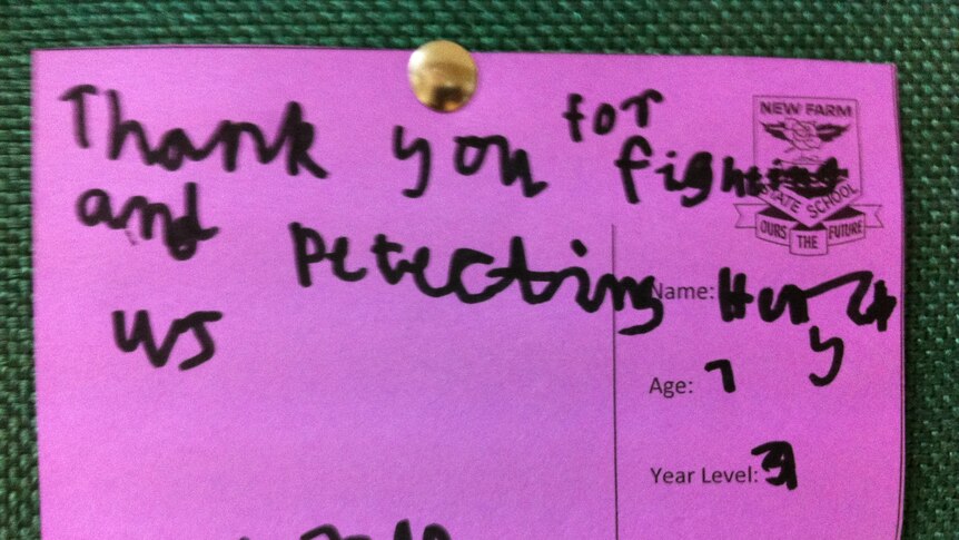 A postcard from a New Farm State School student hangs on a pinboard at an Australian military base in Afghanistan.