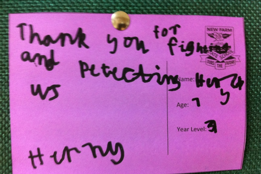 A postcard from a New Farm State School student hangs on a pinboard at an Australian military base in Afghanistan.