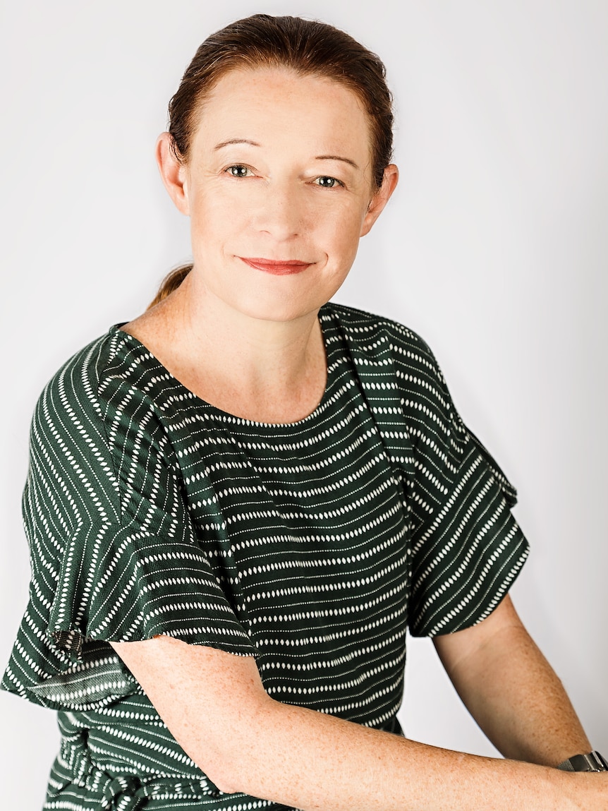 A woman smiles at the camera.