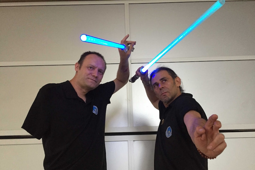 Two men holding blue lightsabers