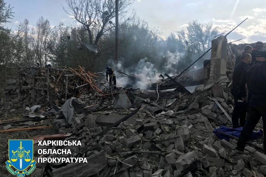 A man clambers over rubble in Ukraine.