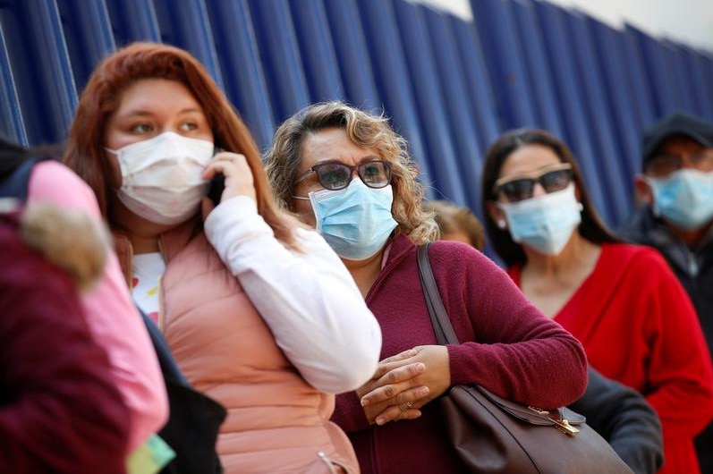 Women in a queue wearing face masks.